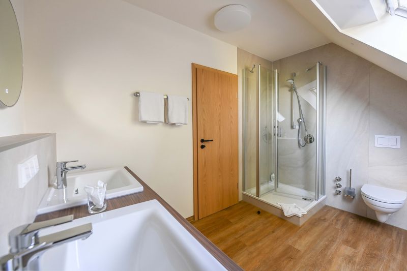 Geräumiges Badezimmer im Dachgeschoss mit zwei Waschbecken, Dusche und WC