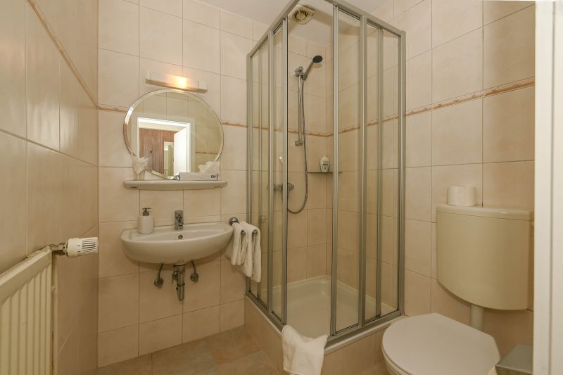 Badezimmer mit Dusche, Waschbecken und WC