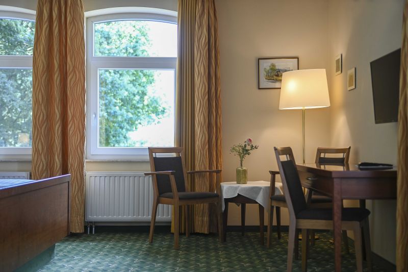 Doppelzimmer mit kleinem Schreibtisch und Sitzecke