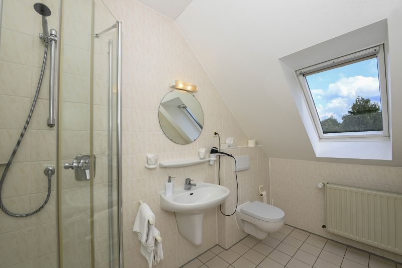 Badezimmer im Dachgeschoss mit Dusche, Waschbecken und WC