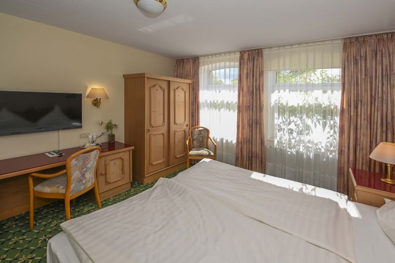 Doppelzimmer im Landhausstil mit Doppelbett, Schrank, Schreibtisch und modernem Flachbildfernseher